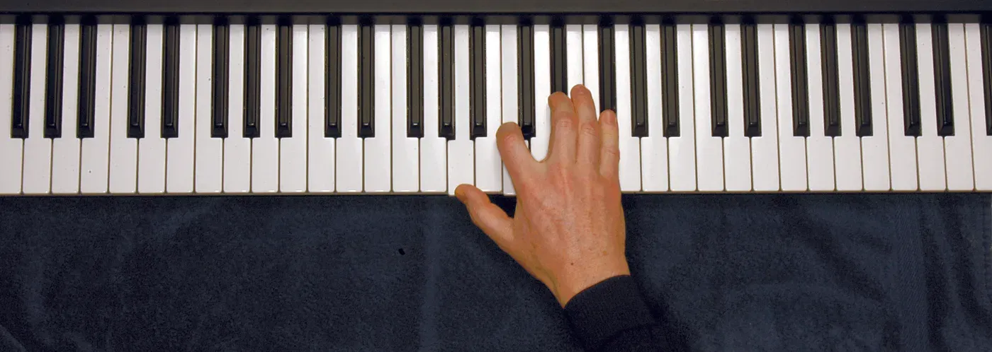Am7b5 chord played on a piano — hand position on the keys