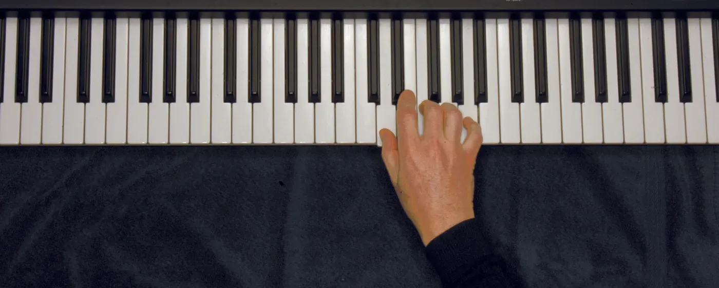 Dm chord played on a piano — hand position on the keys