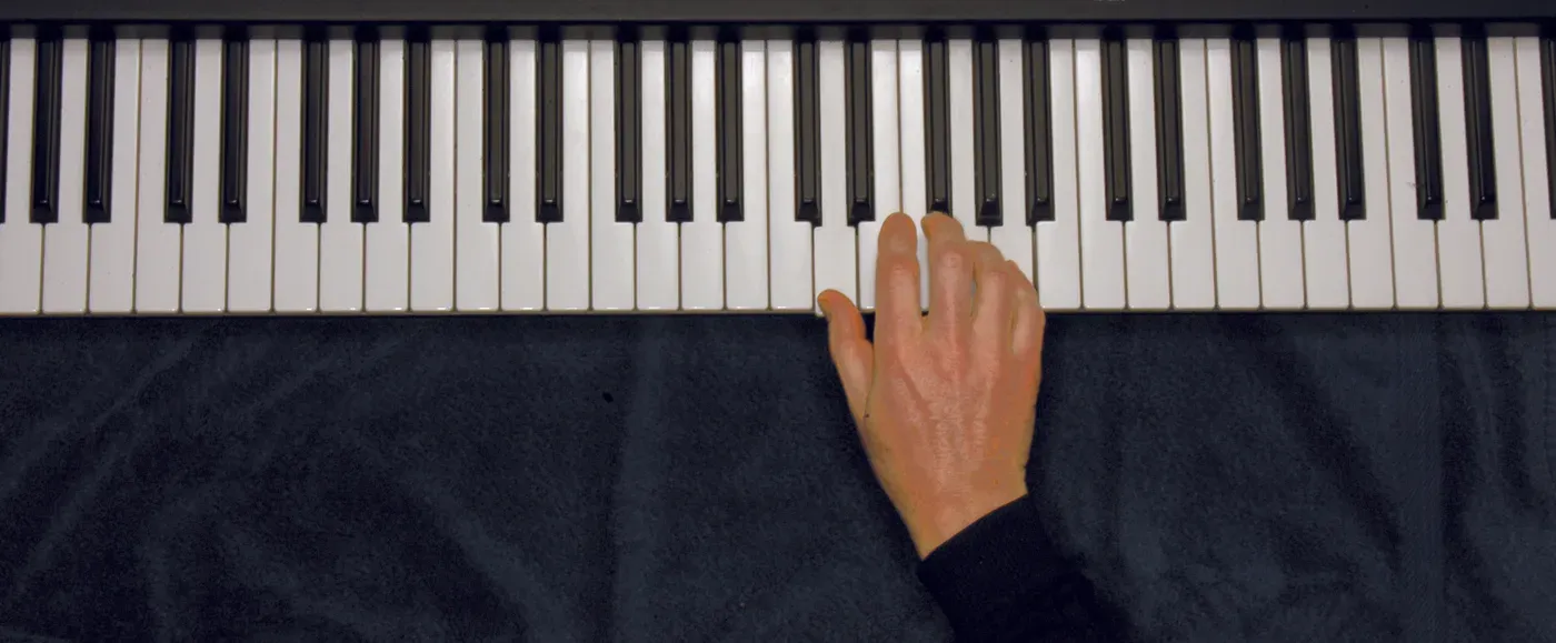 Dsus4 chord played on a piano — hand position on the keys