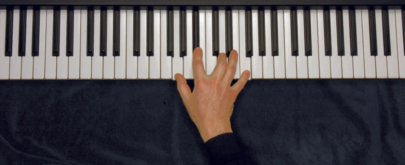 Gm7 chord played on a piano — hand position on the keys